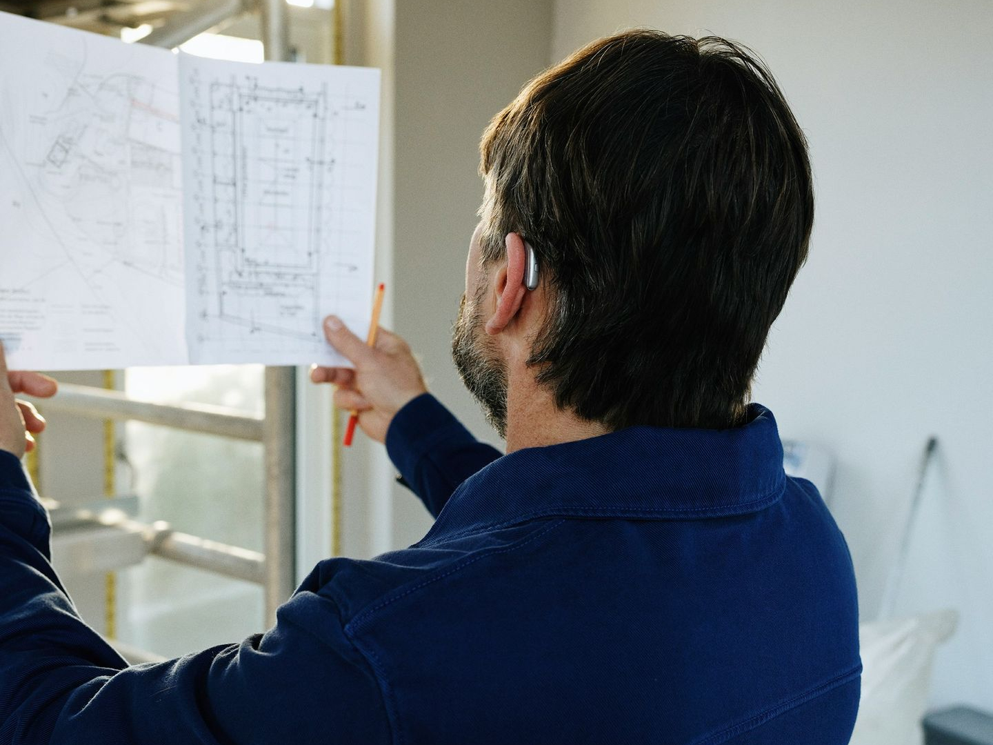 Man reviews blueprints at construction site